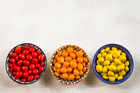 M&M's candy on the white background in bowls, colorful candy and multicolored gradient