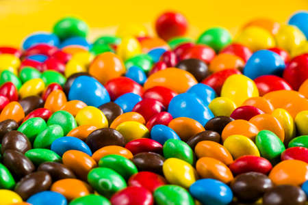 M&M's candy on the yellow background, colorful candy and multicolored gradientの写真素材