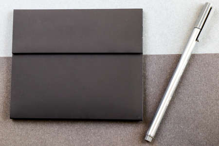 Grey pen and black letter envelope on the black and gray papers background and texture, gray...
