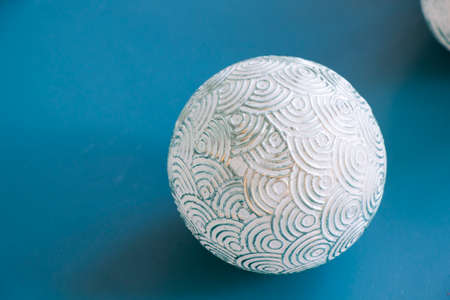 Ball on the blue background, painted christmas ball, gray and white color