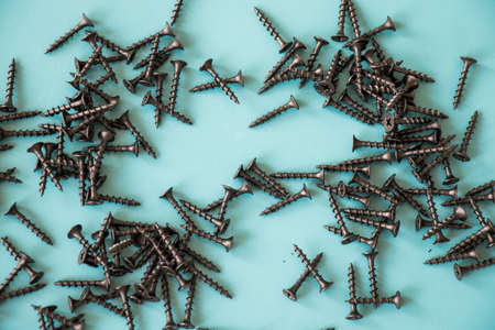 Black threaded screw on the green background, high angle view