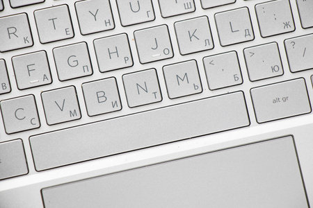 Laptop and notebook computer keyboard close-up, texts, keys and gray board.