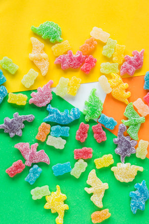 Dinosaurs and bear colorful jelly bonn, candies on the color background