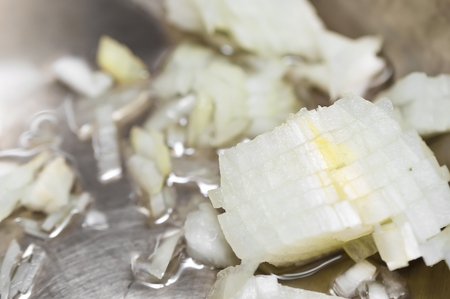Onion cooking in frying pan with oil. Chopped onions.の写真素材