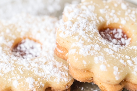 Homemade apricot jam Linzer with icing sugar on the white table close up.の写真素材
