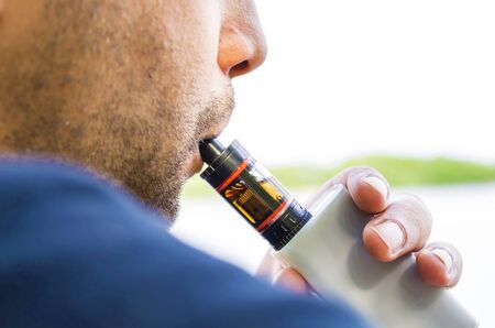 Close up of a man inhaling from an electronic cigaretteの写真素材
