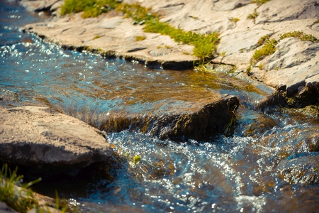 Stream with rocks in the sunshine at mountainの写真素材