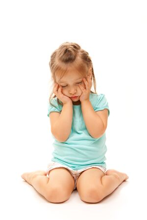 Young girl posing sad on isolated white background.の写真素材