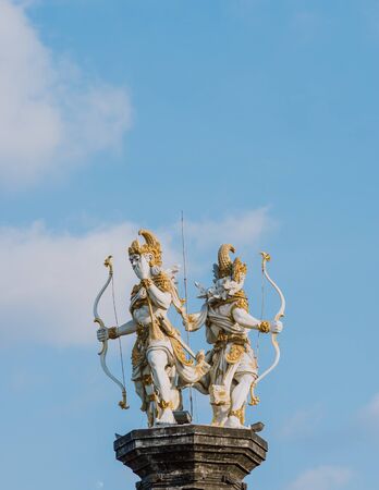 The statue of Nakula & Sadewa stands tall at a height of blue skyの写真素材