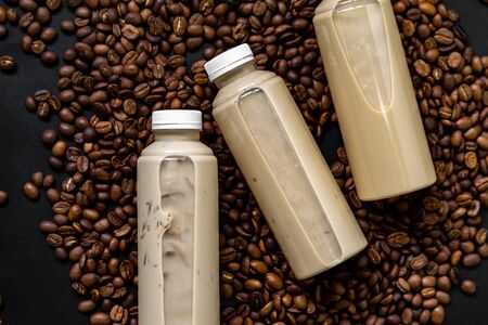 Bottled milk coffee is placed on roasted coffee beans.の写真素材