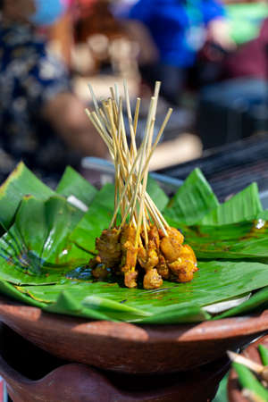 Chicken satay is displayed standing on banana leaves.の写真素材