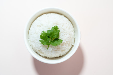 Rice with parsley in a white bowl on a light backgroundの写真素材