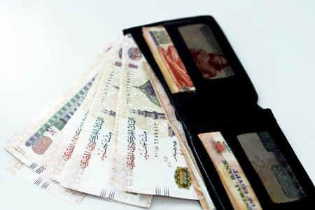 Egyptian money banknote inside a black wallet isolated on a black background, 200 LE two hundred Egyptian pounds bills, Egypt economy, spending money, buying and business concept, selective focusの写真素材