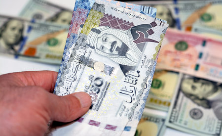 man hand holding a stack of 200 two hundred Saudi riyals banknotes money, spending, giving and using...