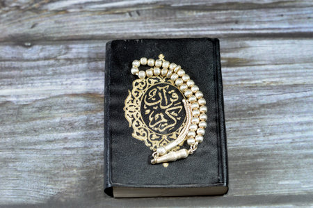 The holy Quran, Qur'an or Koran (the recitation) is the central religious text of Islam, a revelation from God (Allah) with an Islamic silver rosary that Muslims use it to give praise to Allahの写真素材