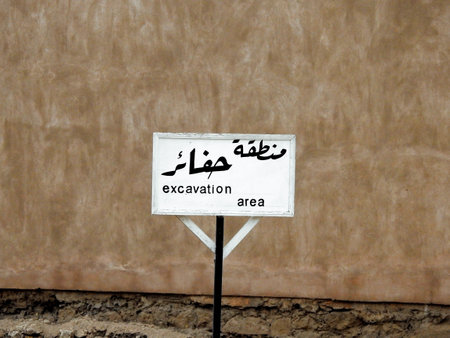 A sign board in Arabic and English languages, Translation (excavation area), as a warning caution for people not to walk in this area for their safety, selective focus of a restricted area signの写真素材