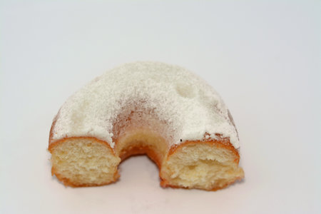 Powdered icing sugar ring donut, A glazed, yeast raised, American style ring doughnut with topping of confectioners' finely ground sugar, type of food made from leavened deep fried dough sweet snackの写真素材