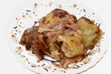 Sweet chocolate mix rolls stuffed with banana fruit pieces, nuts, hazelnuts, raisins, white and brown chocolate sauce with toppings of white and dark chocolate spread chocolate, selective focusの写真素材