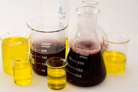 Cairo, Egypt, October 18 2022: A laboratory set of glassware of graduated cylinder, boiling, conical and volumetric flasks that contains yellow and red liquids after a scientific experiment researchのeditorial素材