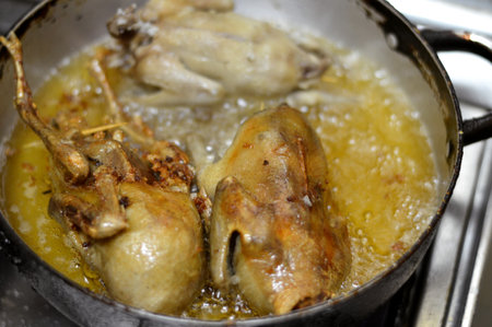 Frying and roasting pigeons stuffed with white rice or Hamam mahshi, boiled until cooked then roasted, fried in hot oil or grilled, stuffed pigeons is a very popular Egyptian cuisine in Egyptの写真素材