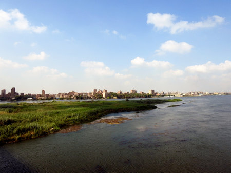 Giza, Egypt, September 9 2022: The Nile river in Egypt, with a village buildings in Giza on its coast, The Nile is a major north-flowing river in northeastern Africa, flows into the Mediterranean Seaの写真素材
