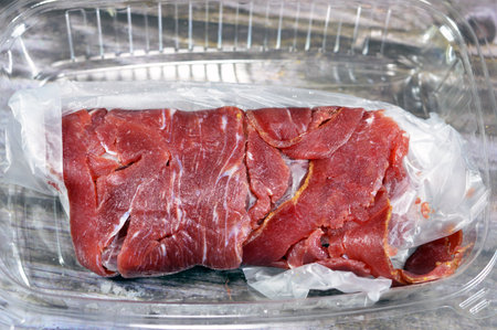 Thin slices of beef pastrami, made from beef brisket, raw meat is brined, partially dried, seasoned with herbs and spices, then smoked and steamed, like corned beef, originating from Romaniaの写真素材