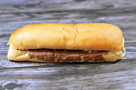 Long bun bread, a fresh baked loaf of bread French Fino, stuffed and filled with sweetened hazelnut cocoa spread, chocolate nougat cream, melted chocolate paste, a quick dessert snack for childrenの写真素材