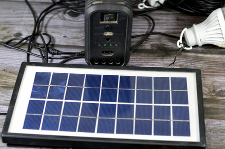 A multi purpose battery charged with a solar panel, a device that converts sunlight into electricity by using photovoltaic (PV) cells which made of materials that generate electronsの写真素材