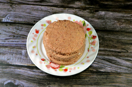 Raw uncooked beef burger ready to be cooked and fried in shallow oil, Fast food, Junk food concept, Home made fast food, beef meat burger ready for frying and served in a burger bun, selective focusの写真素材