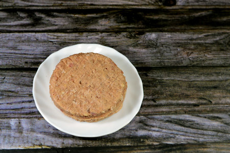 Raw uncooked beef burger ready to be cooked and fried in shallow oil, Fast food, Junk food concept, Home made fast food, beef meat burger ready for frying and served in a burger bun, selective focusの写真素材