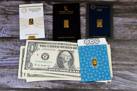 Cairo, Egypt, January 2 2024: Money banknotes of American dollars USD, United States of America money, SAM, BTC, Swiss Gold, Gold Era 24 Karate pure yellow gold bars, investment, exchange price rateのeditorial素材