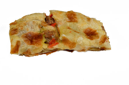 Middle Eastern meat sausage pie baked in the oven and sliced into pieces, with pieces of beef sausage, minced meat, tomatoes, peppers, herbs and spices ready to be served, selective focusの写真素材