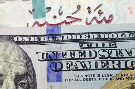Closeup Egyptian money banknotes of 100 EGP LE one hundred pounds bill and USD American cash of 100...