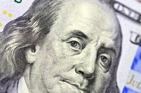 A close up of the obverse side of 100 USD one hundred American dollars bill features Benjamin...