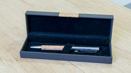 Closeup metal silver pen with a cork element in a gift box. On wooden desk background.の写真素材