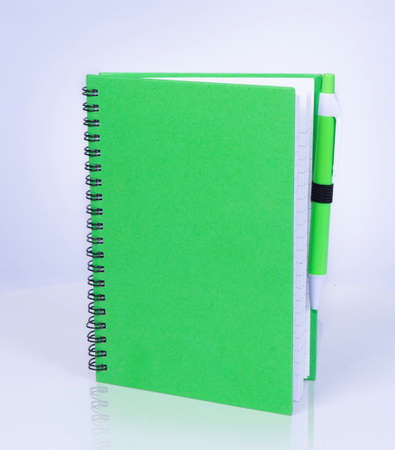 Green spiral notepad and pen Business style. On white background.の写真素材