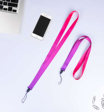 red purple Polyester Cell Phone Holder Neck Lanyard With Plastic Clip. On desk officeの写真素材