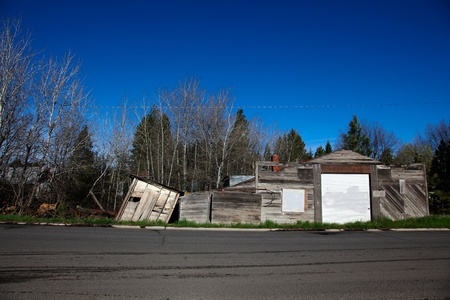 Worley, Idaho, May 2, 2010: A springtime view of a rural street in Northern Idaho with a forgotten garage, falling down shed, and a metal junk yard.のeditorial素材