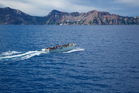 Crater Lake, Oregon, August 10, 2010: A boat full of tourists taking a ride on the deepest and bluest lake in the United States. のeditorial素材