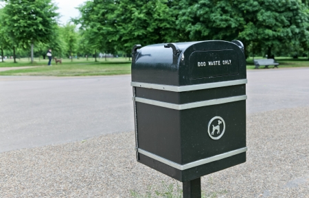 A black metal receptacle marked for dog waste only in a park in London, England.の写真素材