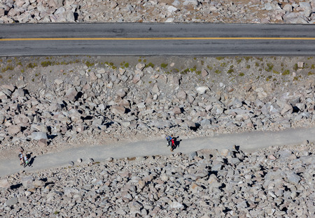Hikers descending on the Watchman Peak Trail next to the rim road at Crater Lake National Park in...