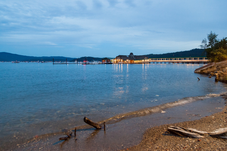 COEUR D'ALENE, IDAHO, USA - JULY 4, 2018: The Cedars floating restaurant on Lake Coeur d'Alene at twilight with boats in the background on the Fourth of July in Coeur d'Alene, Idaho.のeditorial素材