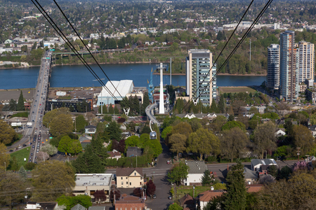 PORTLAND, OREGON - April 14, 2014:  A tram car view of city buildings and Ross Island Bridge crossing the Willamette River in Portland, OR on April 14, 2014.のeditorial素材