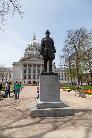 MADISON, WISCONSIN - May 10, 2014:  A small child peeking around a statue of Colonel Hans Christian Heg at the eastern entrance to the capital building in Madison, WI on May 10, 2014.のeditorial素材