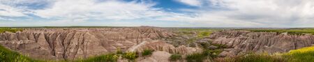 A panoramic view of dramatic mountain formations carved out by erosion showing layers of rocks with...