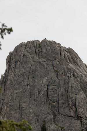 A couple of people standing on top of a giant quartz rock formation with a cloudy background in Custer State Park, South Dakota.の写真素材