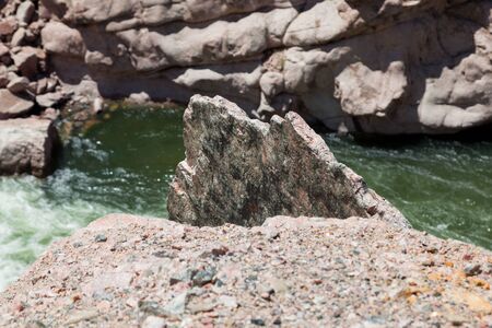 A large slab of granite sticks up from the embankment of the Bighorn River as it winds its way...