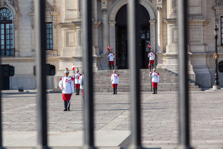 LIMA / PERU - May 10 2016: Guards in red and white uniforms, metal hats, and ceremonial swords and...