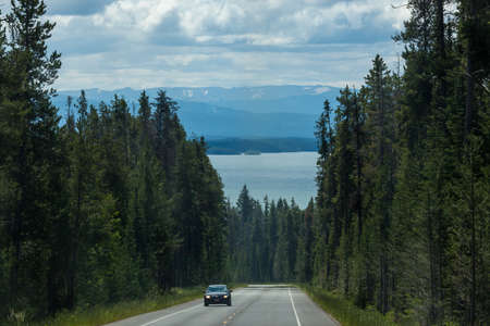 Grand Teton National Park, Wyoming / USA - July 16, 2014:  A view of Jackson Lake as seen from John D. Rockefeller Jr. Memorial Parkway with distant mountains and tall trees in Grand Teton National Park, Wyoming.のeditorial素材