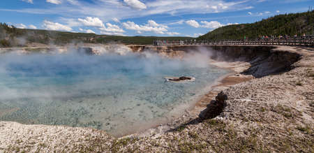 Yellowstone National Park, Wyoming / USA - July 22, 2014:  A group of tourists standing on a wooden walkway next to Excelsior Geyser Crater at Yellowstone National Park in Wyoming.のeditorial素材
